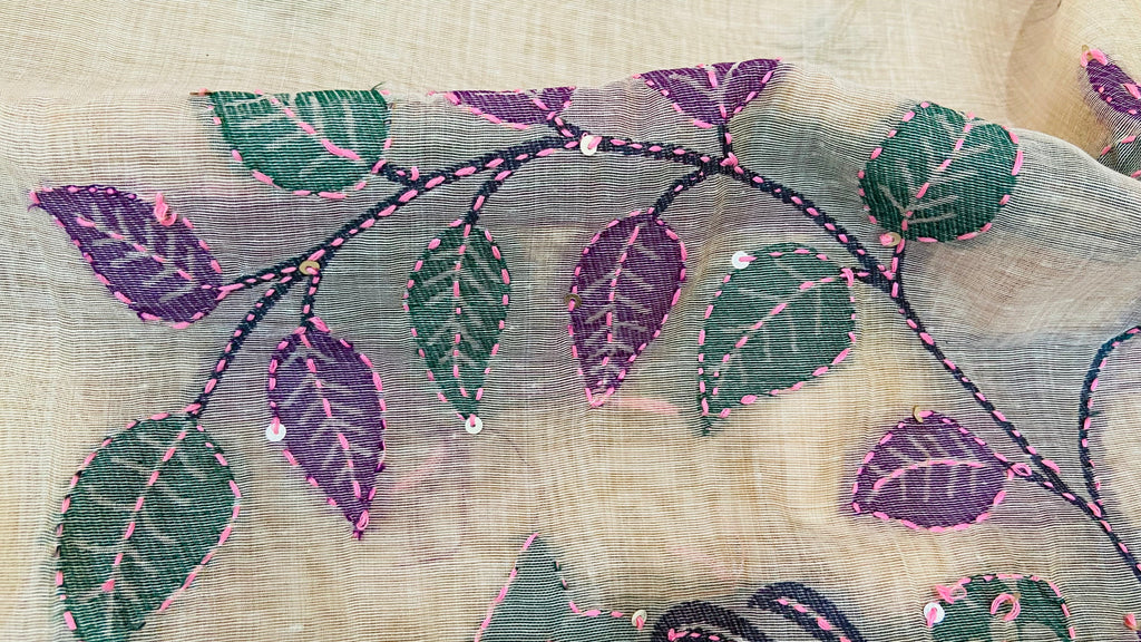 Embroidered fabric with purple and green leaves on a beige background